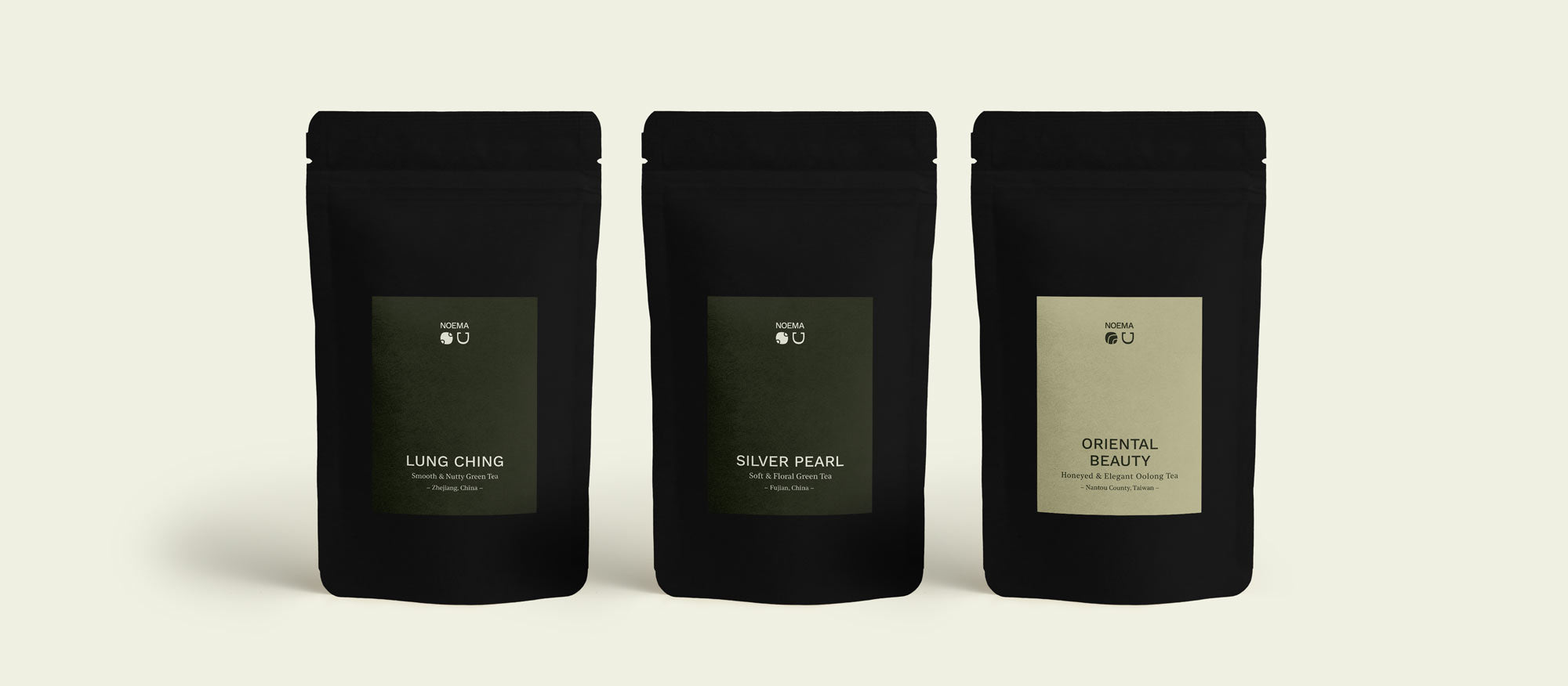 Noema Tee Probierpaket ‘Klarheit & Frische’ mit den drei Sorten Lung Ching, Silver Pearl und Oriental Beauty, die Packungen stehen sichtbar im Bild.